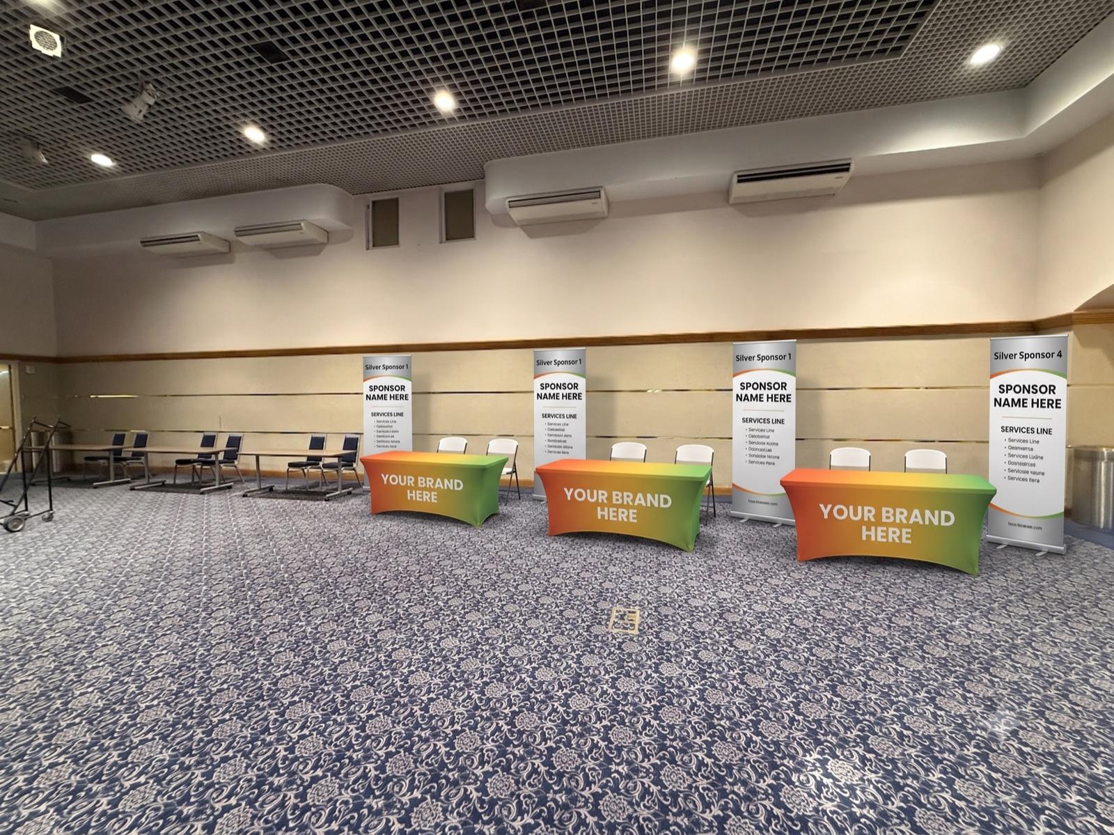 A row of four Silver sponsor booths along a shared wall, each with a vertical banner and branded table